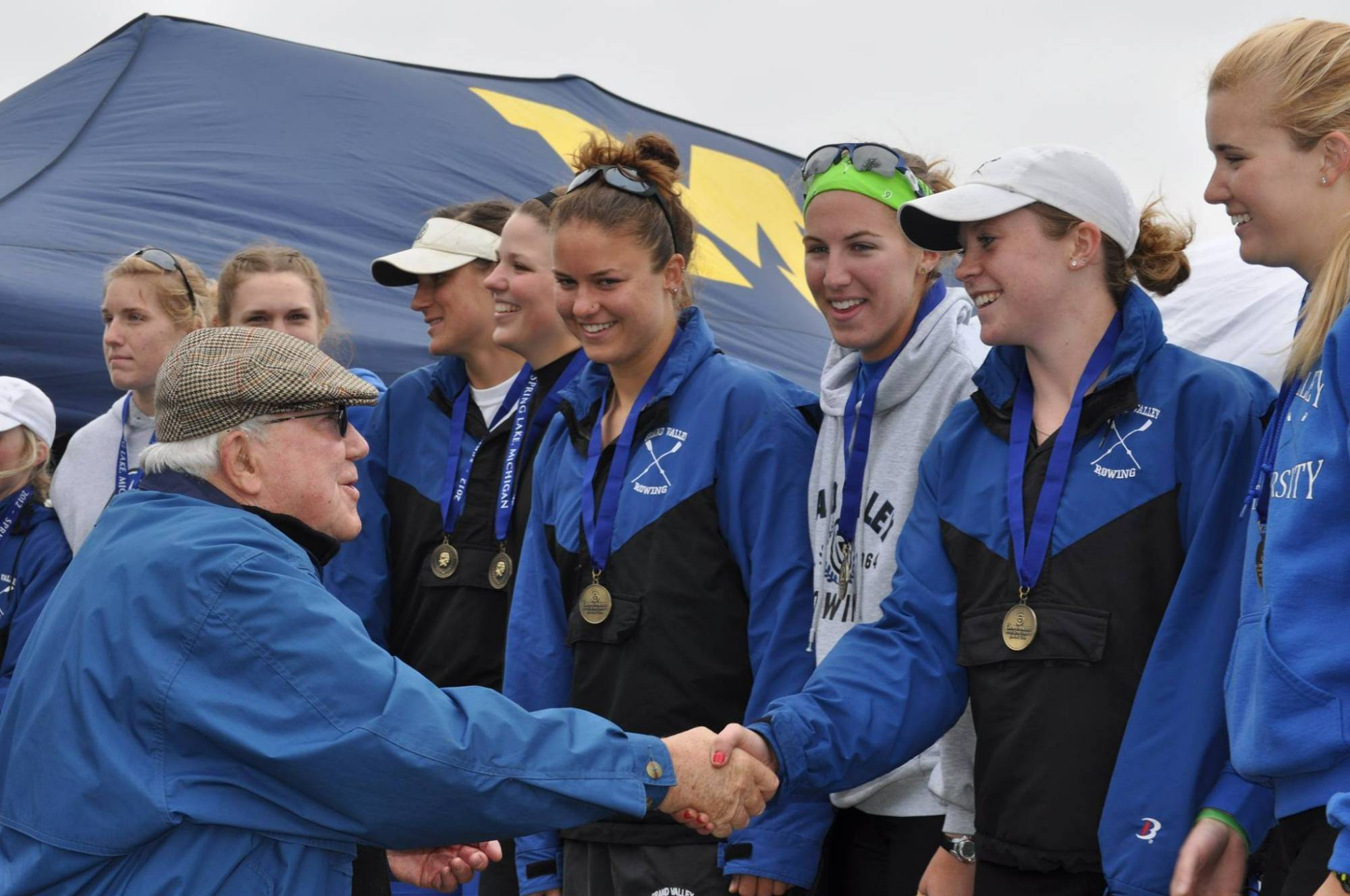 President Emeritus Don Lubbers congratulates winners of the women's varsity 8+ event.